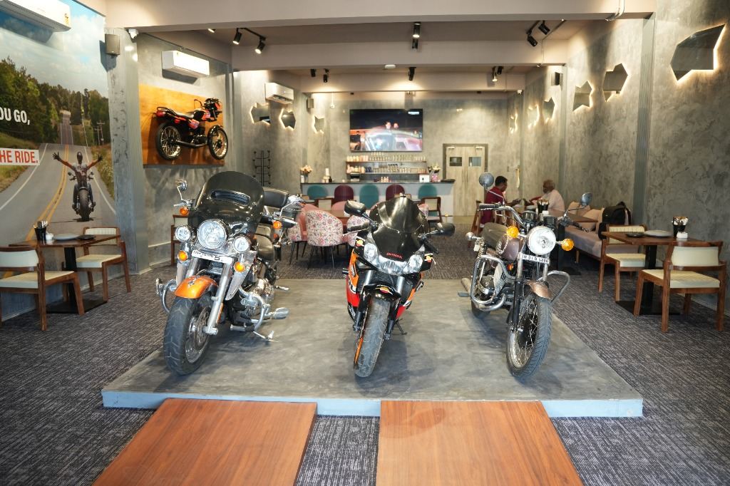 EBD Café showroom interior with three motorcycles on display platform
